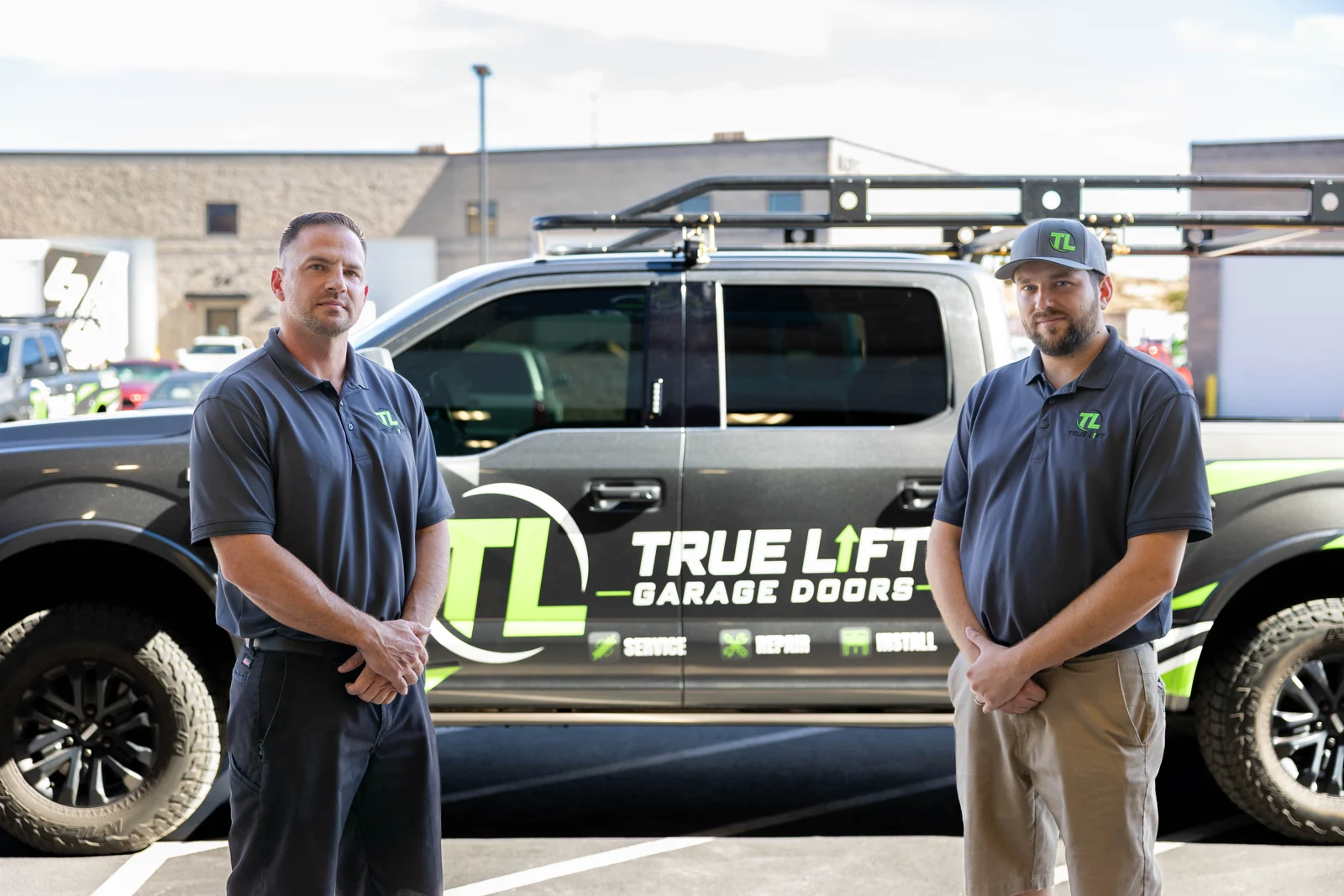 Two True Lift team members standing beside their company truck.