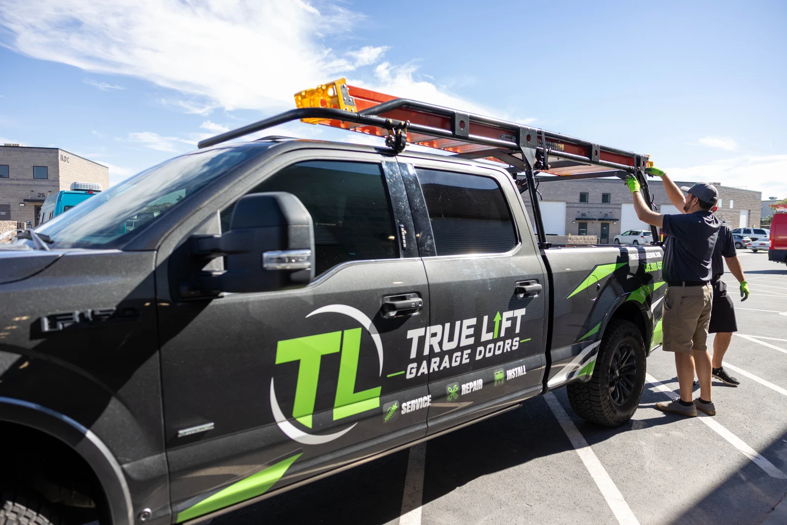 True Lift truck with a team member loading the ladder rack.