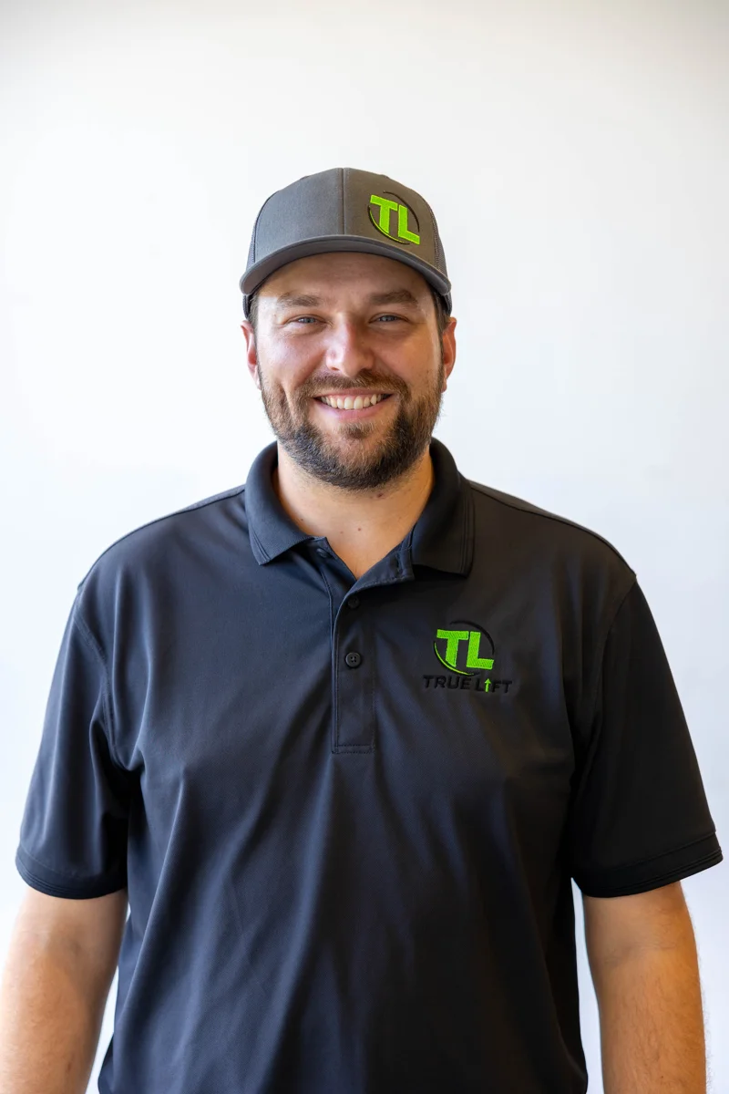 Colin, co-owner of True Lift Garage Doors, wearing a company cap and polo.